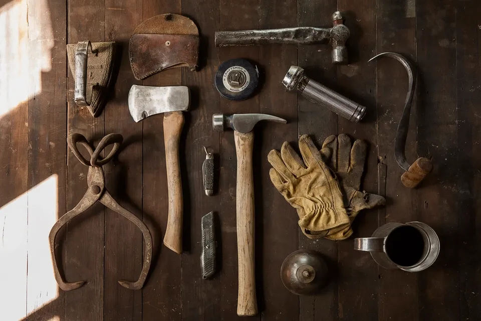 A carpenter's tools laid out neatly on a wooden floor
