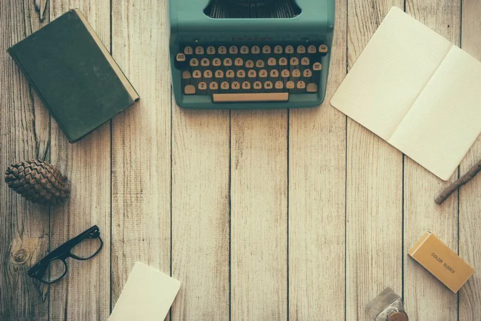 A vintage typewriter on a wooden desk from above